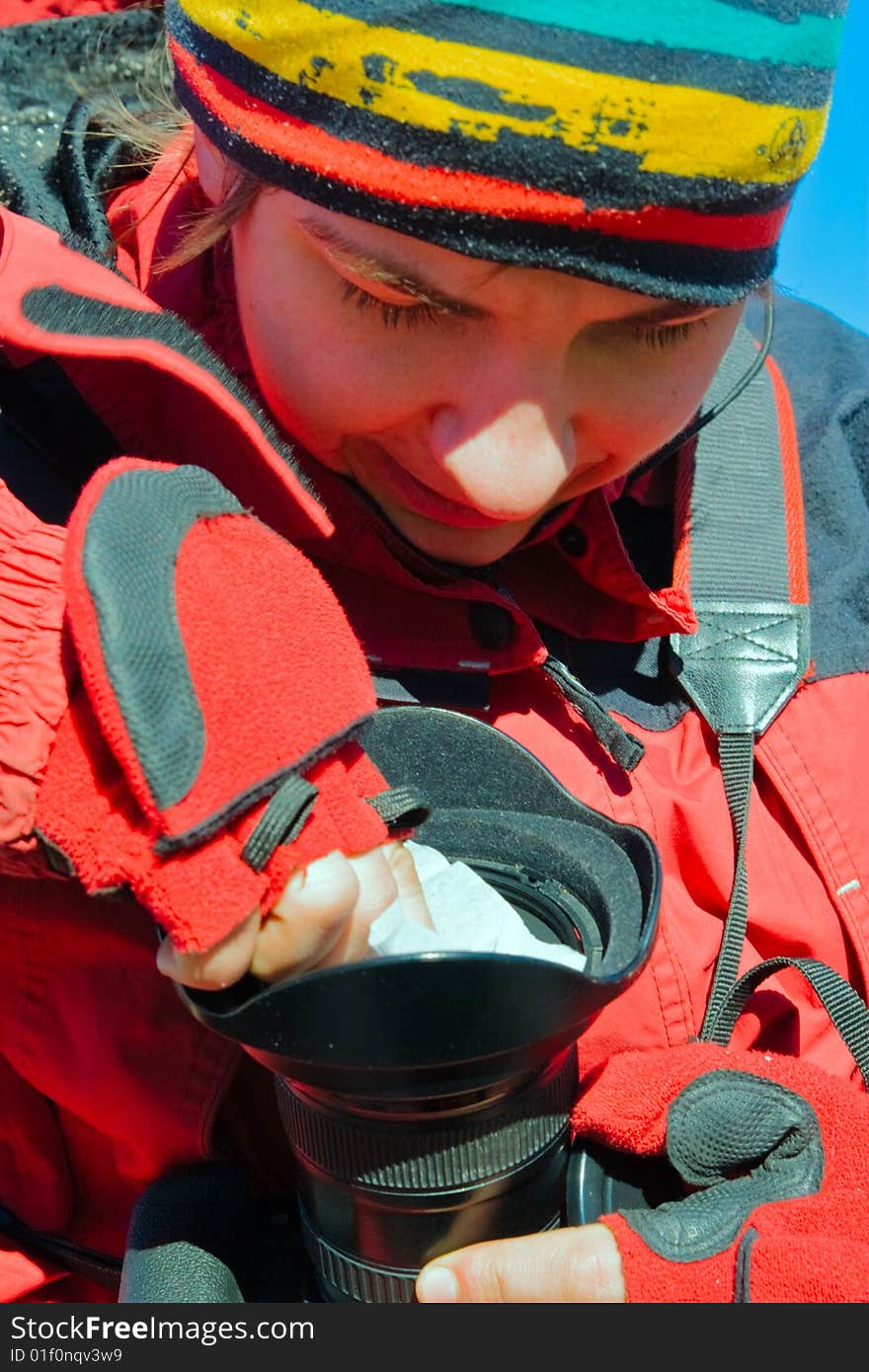 Tourist photographer cleans camera lens with white tissue. Tourist photographer cleans camera lens with white tissue