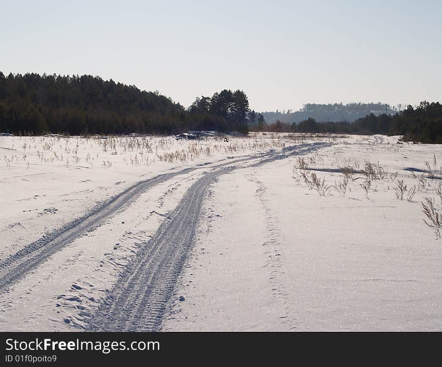 Winter road through a snow field