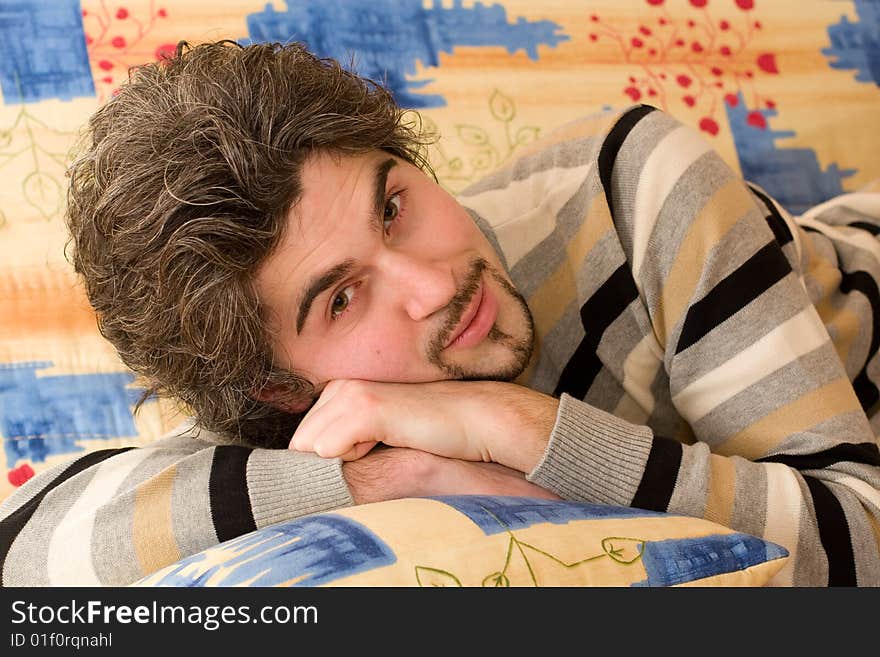 Young handsome male on colourful sofa