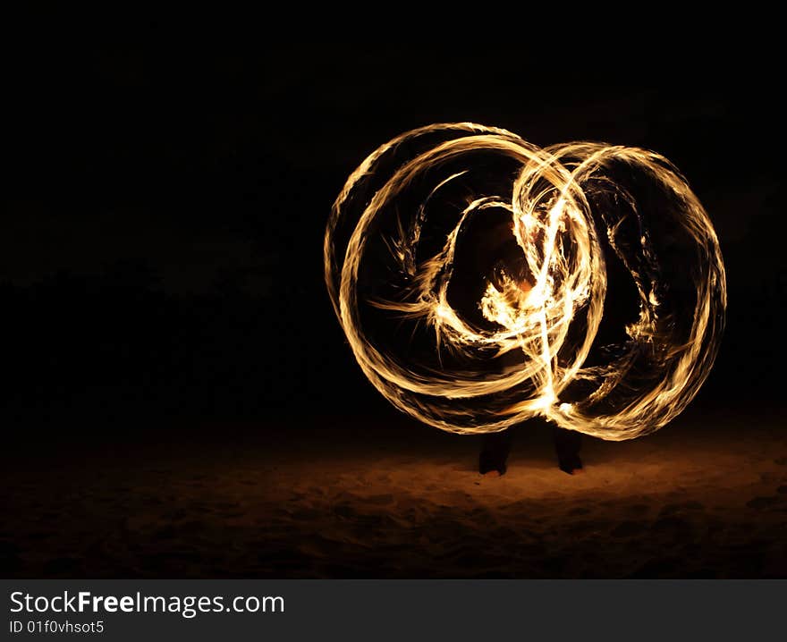 Fire dancer making circles of fire on the beach. Fire dancer making circles of fire on the beach