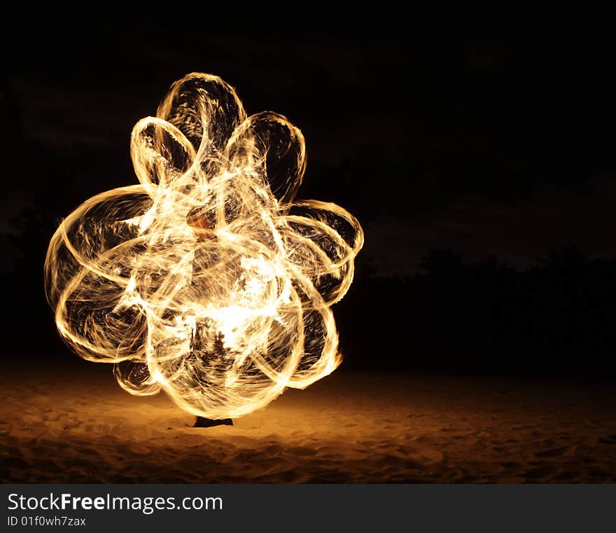 Fire dancer making circles of fire on the beach. Fire dancer making circles of fire on the beach