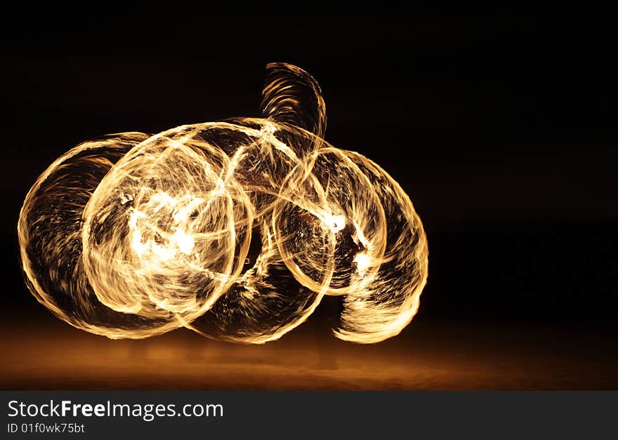 Fire dancer making circles of fire on the beach. Fire dancer making circles of fire on the beach