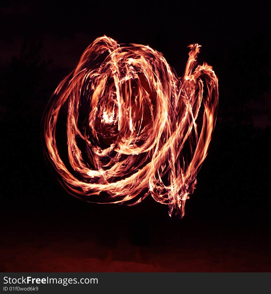 Fire dancer making circles of fire on the beach. Fire dancer making circles of fire on the beach