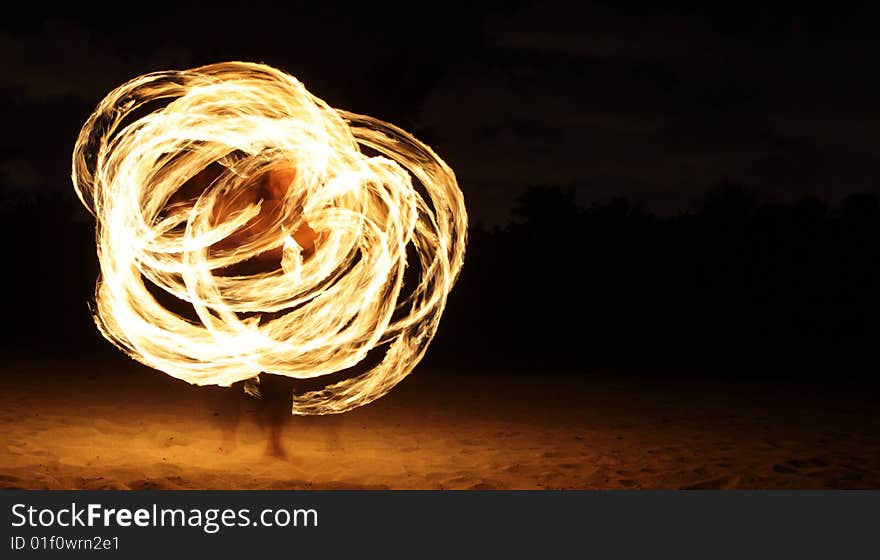 Fire dancer making circles of fire on the beach. Fire dancer making circles of fire on the beach