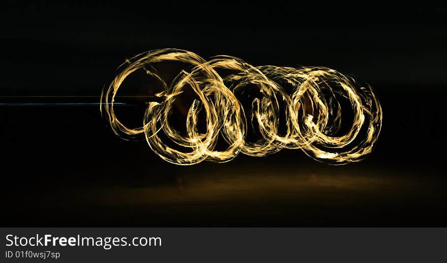 Fire dancer making circles of fire on the beach. Fire dancer making circles of fire on the beach