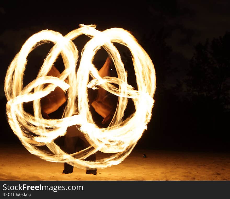 Fire dancer making circles of fire on the beach. Fire dancer making circles of fire on the beach