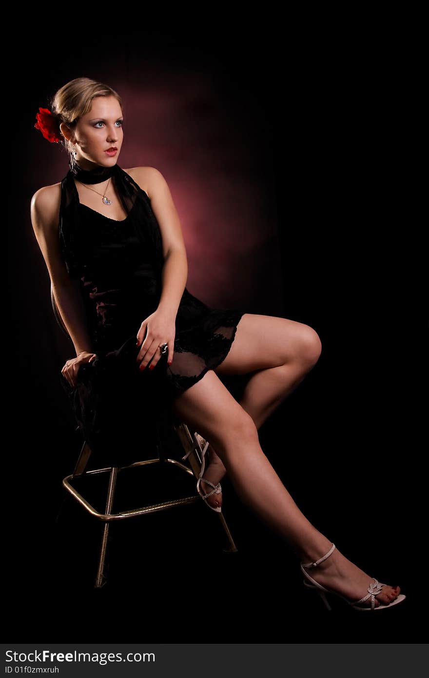 Young lady in black dress sitting on a chair. Young lady in black dress sitting on a chair