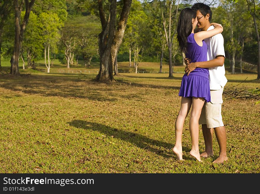 A loving couple enjoying intimate moments in the outdoor. A loving couple enjoying intimate moments in the outdoor