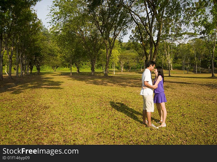 A loving couple enjoying intimate moments in the outdoor. A loving couple enjoying intimate moments in the outdoor