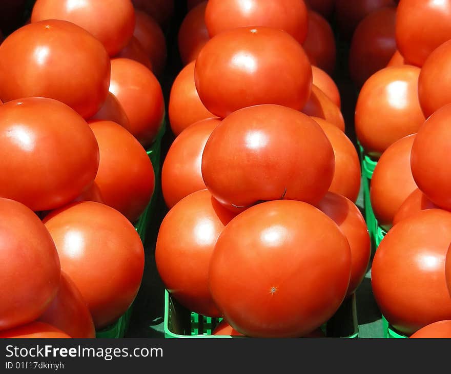 A display of ripe red yummy looking tomatoes at the local farmer's market. A display of ripe red yummy looking tomatoes at the local farmer's market.