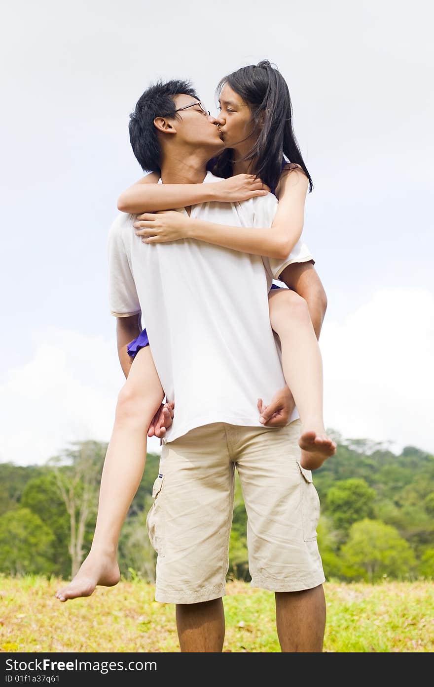 A loving couple enjoying intimate moments in the outdoor. A loving couple enjoying intimate moments in the outdoor