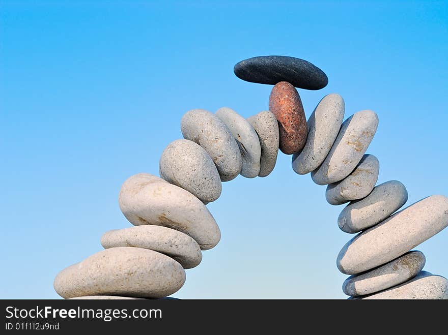 White sea pebble combined in an arch with a black stone with top. White sea pebble combined in an arch with a black stone with top