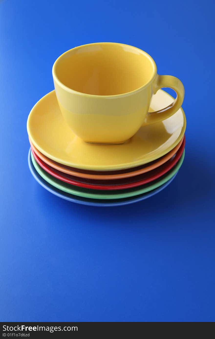 Yellow cup, five plates on blue background.