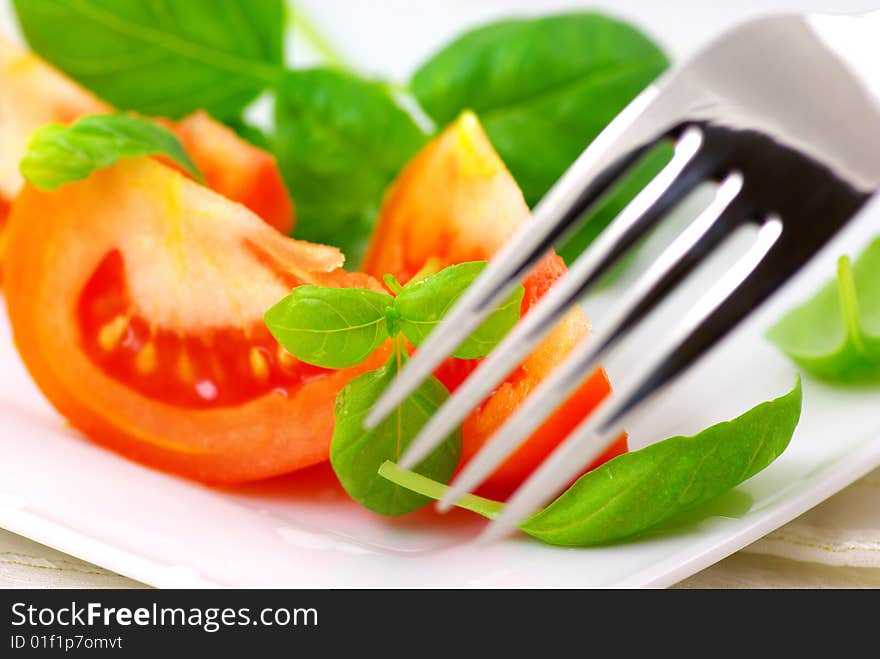 Fresh tomatoes with basil on a plate. Fresh tomatoes with basil on a plate