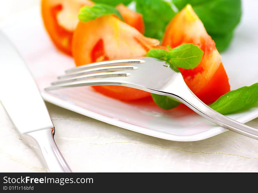 Fresh tomatoes with basil on a plate. Fresh tomatoes with basil on a plate