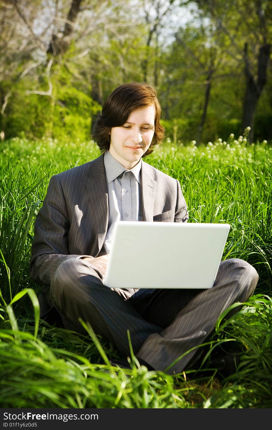 Man with laptop on the grass. Man with laptop on the grass