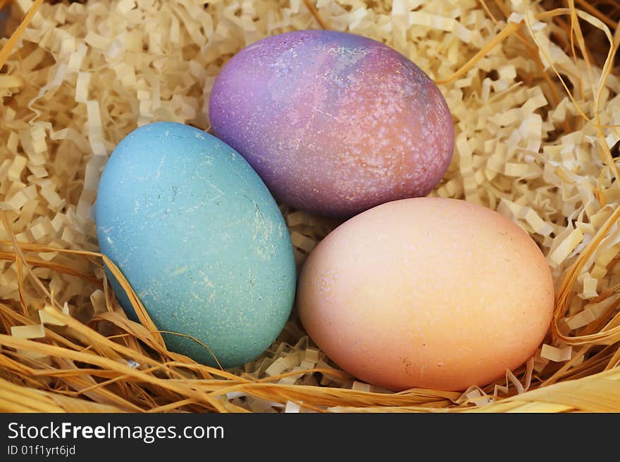 Three colorful easter eggs in wicker basket