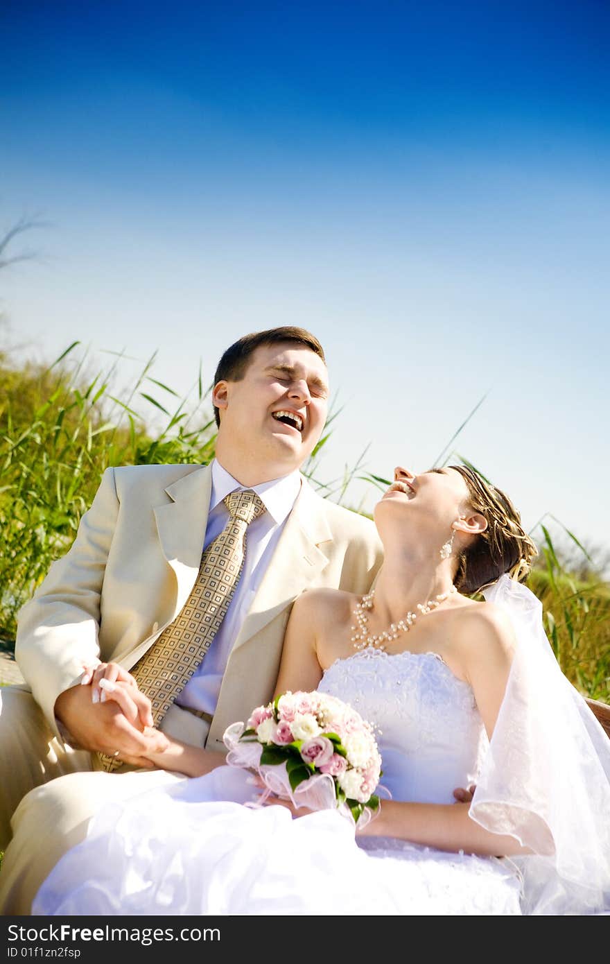 Laughing bride and groom outdoors. Laughing bride and groom outdoors