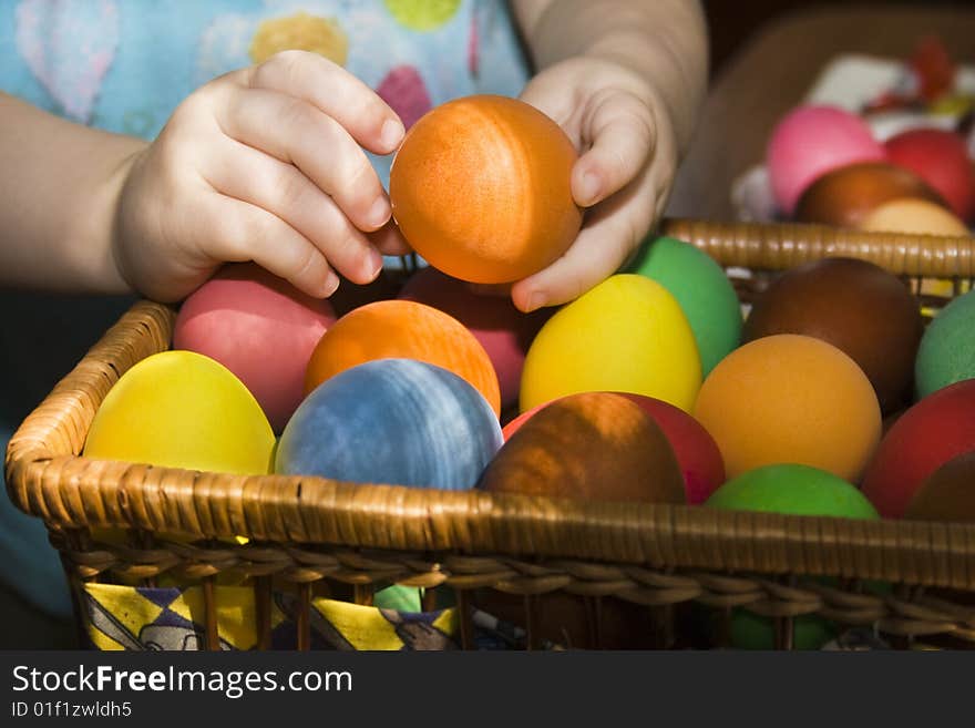 Child hands holding a multi colored egg. Child hands holding a multi colored egg.