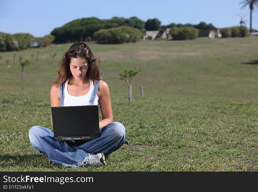 Young woman with laptop at the park