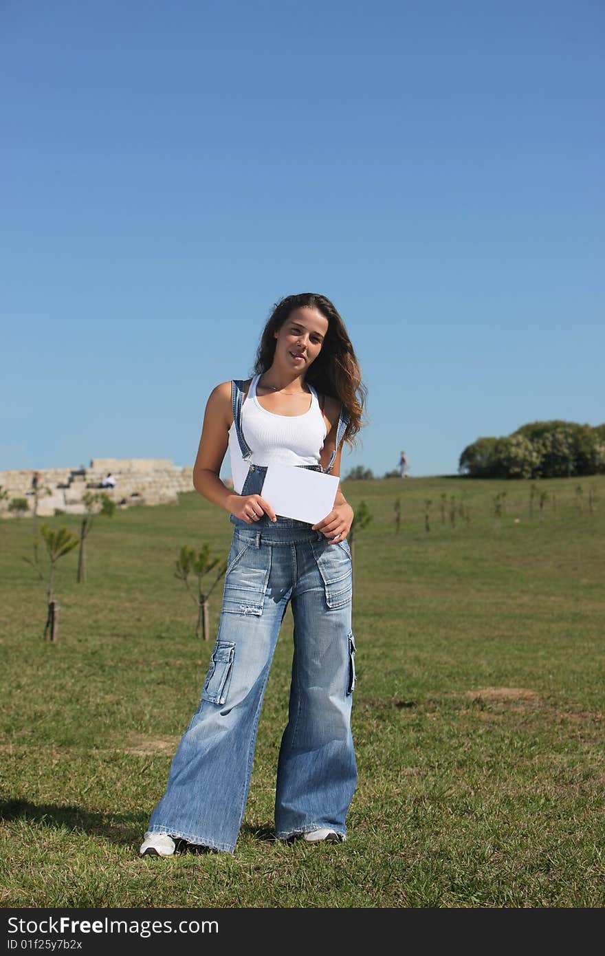 Portrait of a beautiful woman holding a white card (focus on the card)