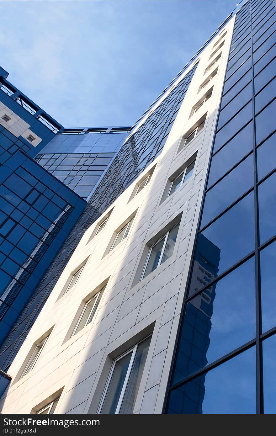 Glass facade of a modern urban building with glass windows. Glass facade of a modern urban building with glass windows