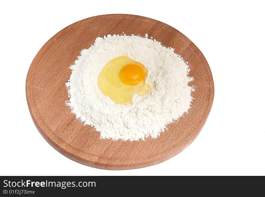 Flour and  eggs on wooden board.