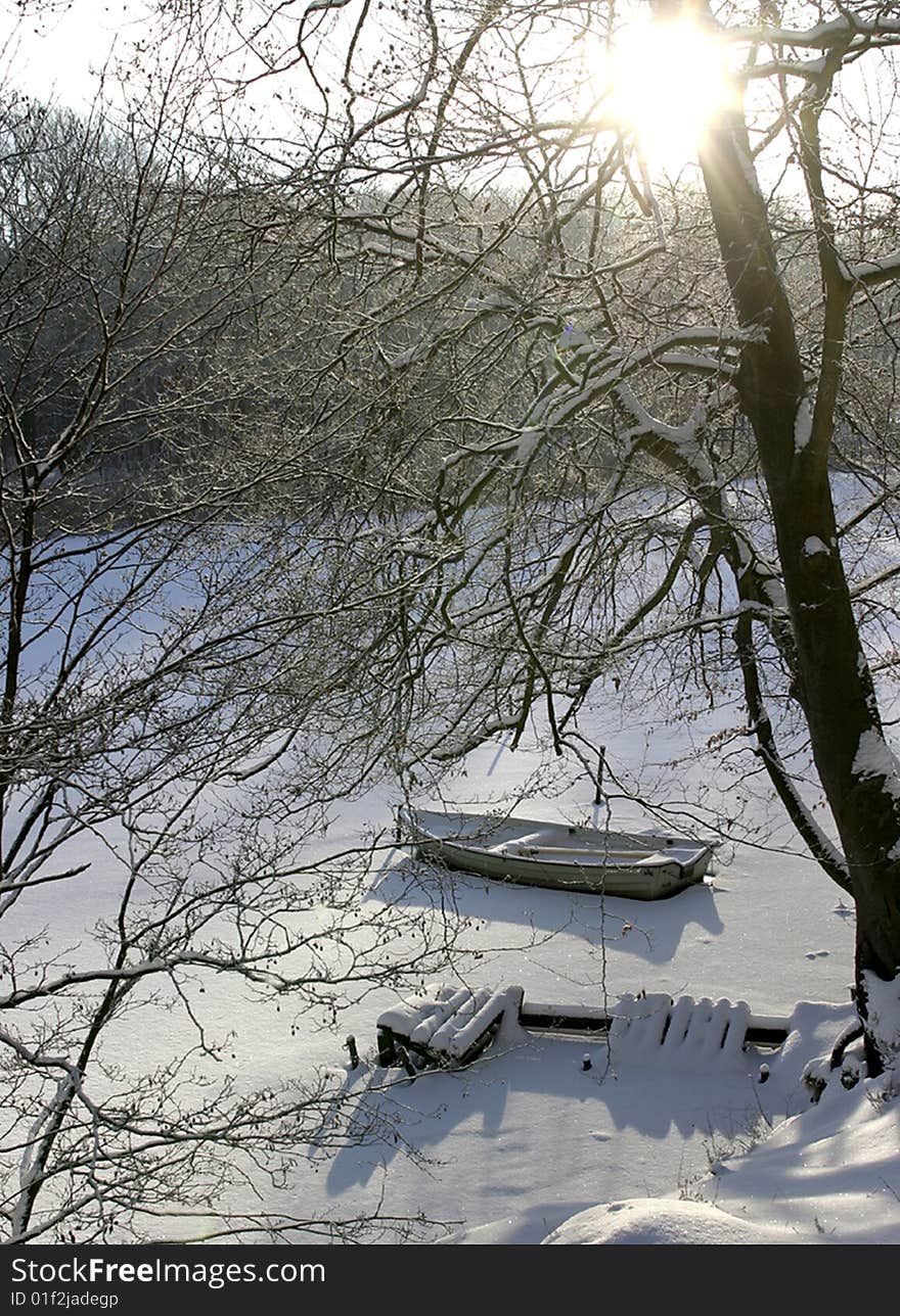 The winter sun casts its beams on the boat and the ramshackled bridge. The winter sun casts its beams on the boat and the ramshackled bridge