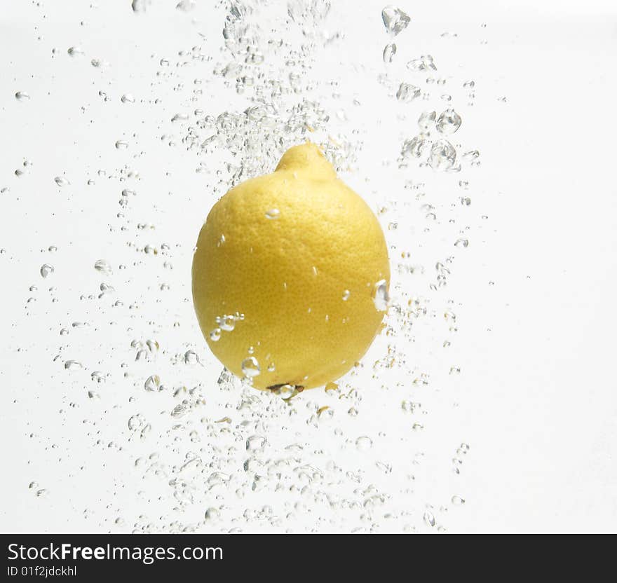 Alone lemon is dropped into fresh water.