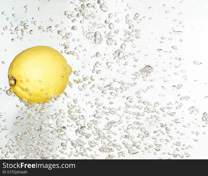 Splash bubbles after dropped lemon into clean water. Splash bubbles after dropped lemon into clean water.