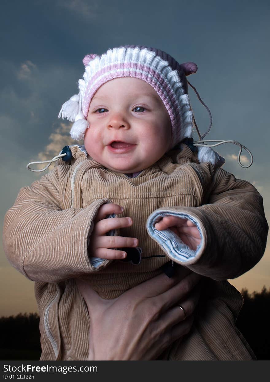 Little baby outdoors on blue sky background