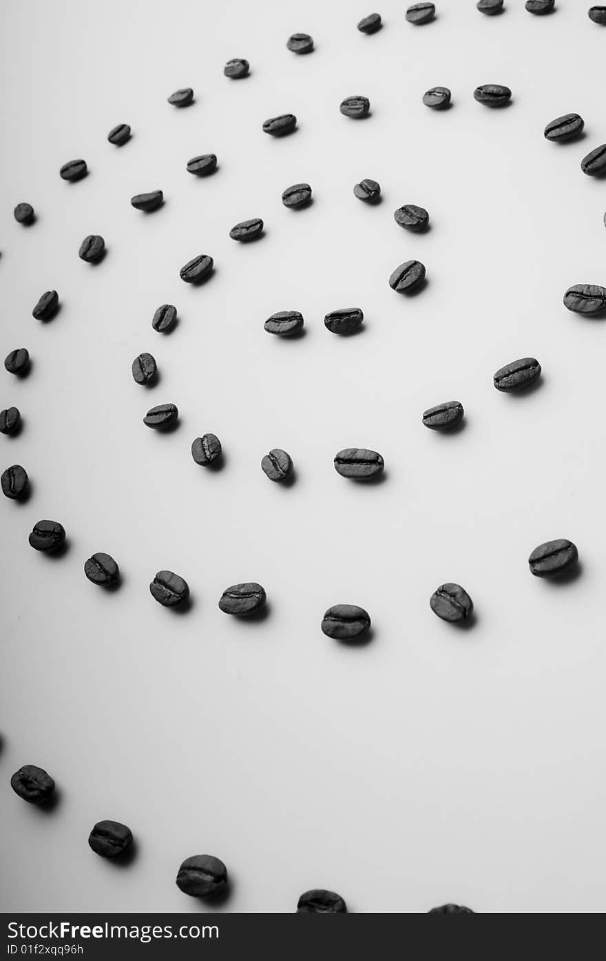 Coffee spiral made of coffee grains on an inclined white surface