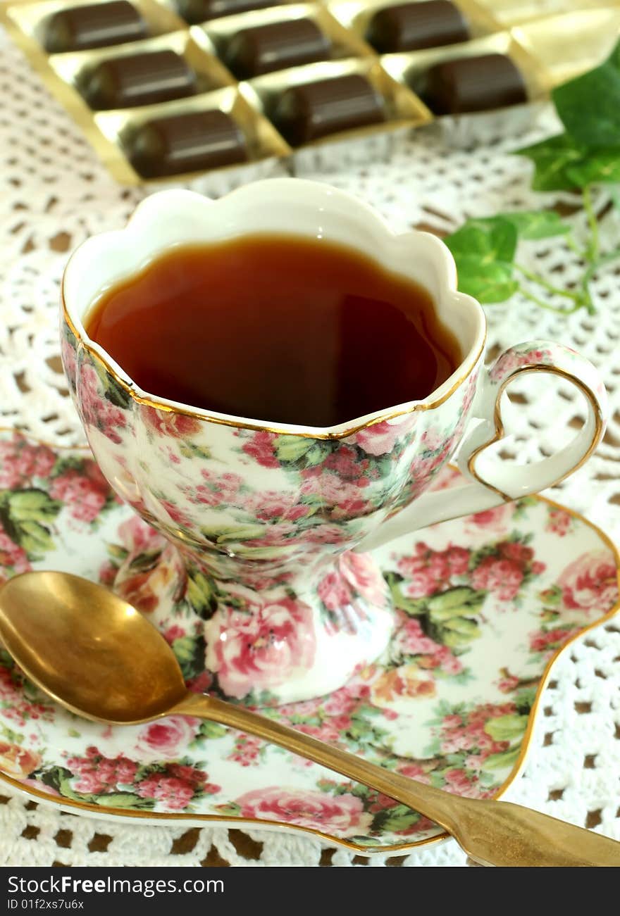 Cup of tea and chocolates on knitted table cover