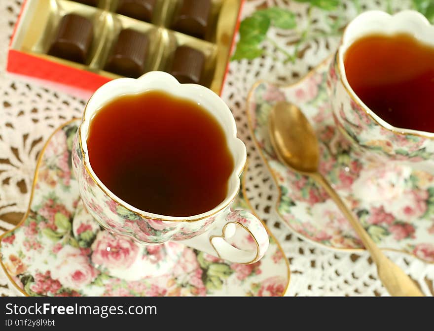 Cup of tea and chocolates on knitted table cover