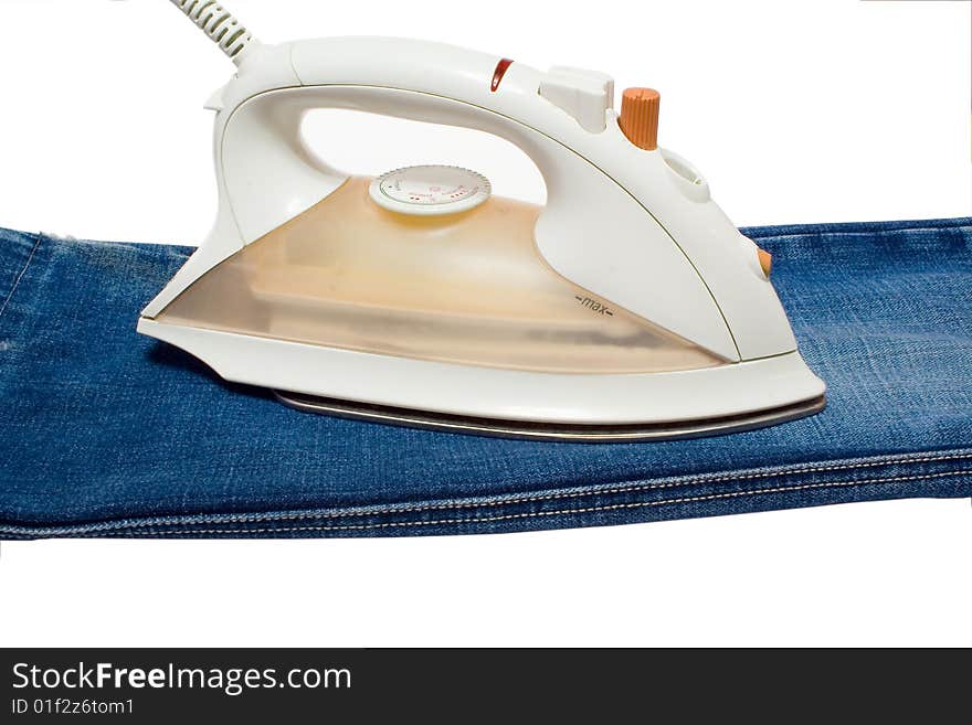 Electric iron on jeans. An isolated white background