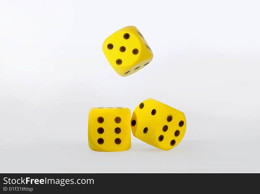 Gambling with three yellow dice,isolated over white.