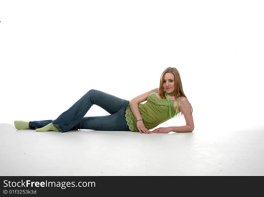 Pretty young woman in green shirt reclining on floor