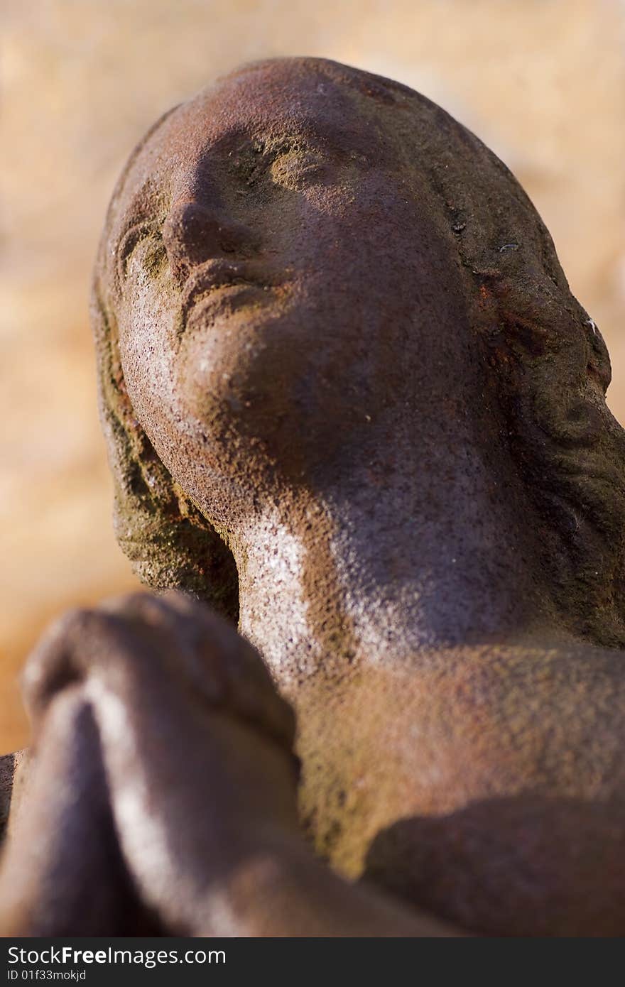 Statue of a Rusty iron woman praying