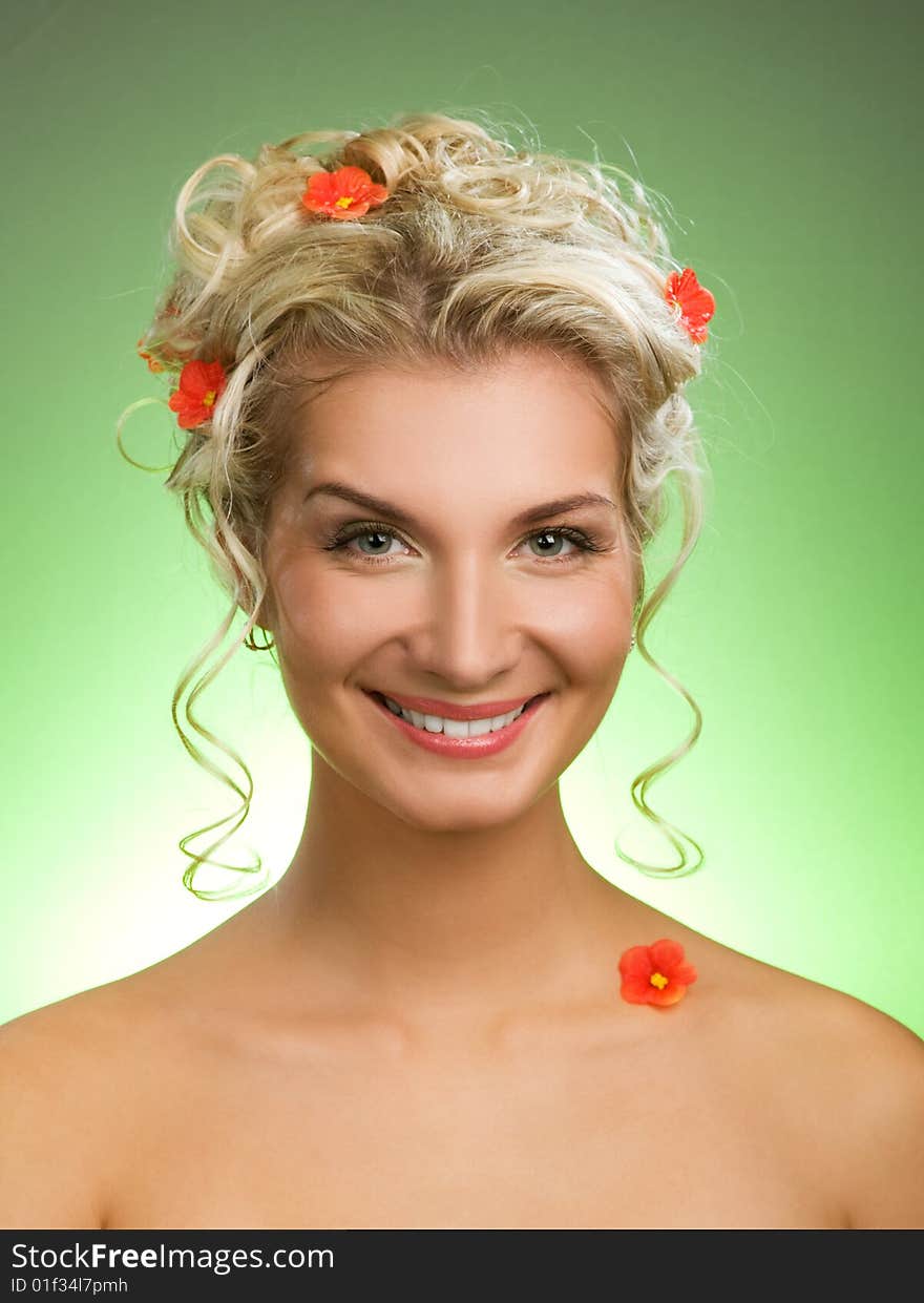 Beautiful young woman with fresh spring flowers in her hair. Spring concept.