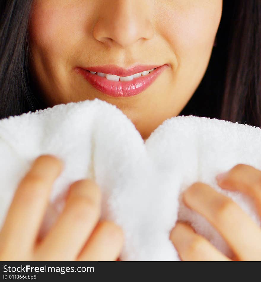 Close up of a woman hugging and smelling a fresh white towel. Close up of a woman hugging and smelling a fresh white towel.