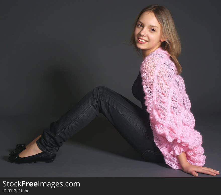 Laughing teenage girl on gray floor