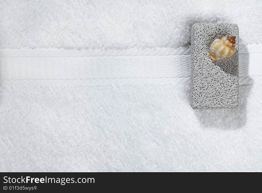 White bath towel and pumice stone display. White bath towel and pumice stone display.