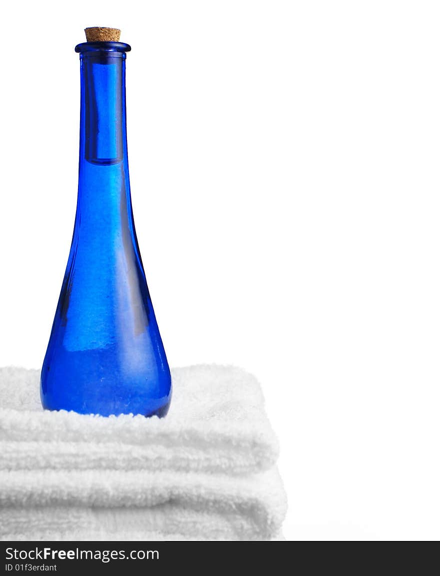 Blue glass corked bottle and towels against white. Blue glass corked bottle and towels against white.