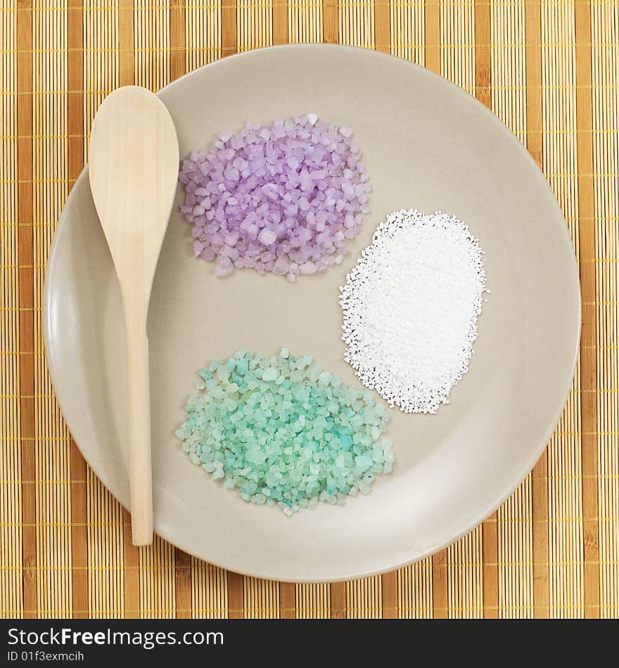 Colorful bath salts on display against a bamboo mat. Colorful bath salts on display against a bamboo mat.