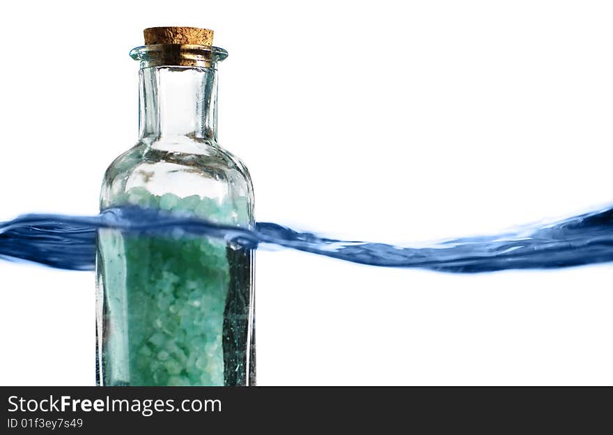 Bottle of bath salts sitting in a blue wave of water. Bottle of bath salts sitting in a blue wave of water.