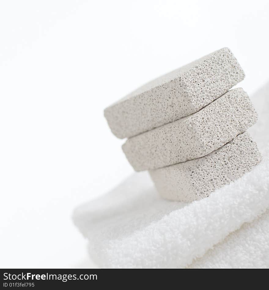 Pumice stones on towels against a white background. Pumice stones on towels against a white background.