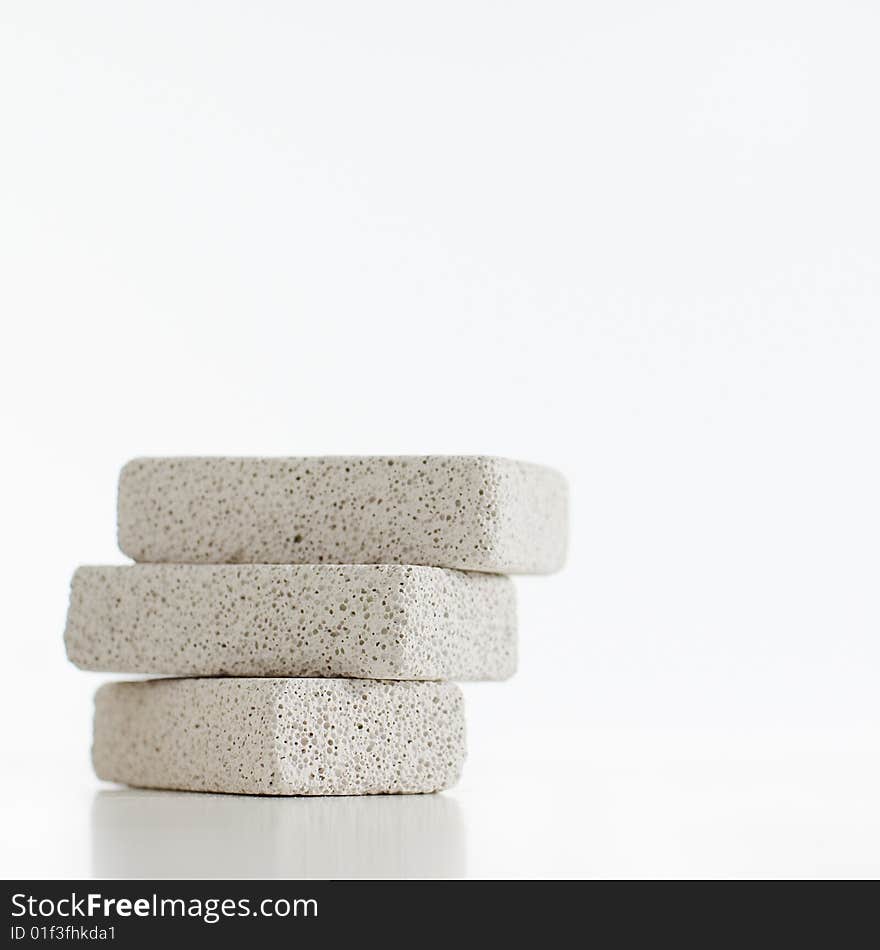 Pumice stones against a white background, sleight reflection. Pumice stones against a white background, sleight reflection.