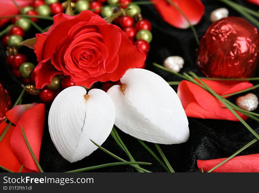 Red rose with heart shaped seashells and beads