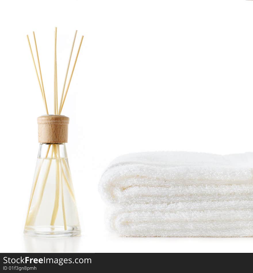 Diffuser and stack of towels against a white background. Diffuser and stack of towels against a white background.