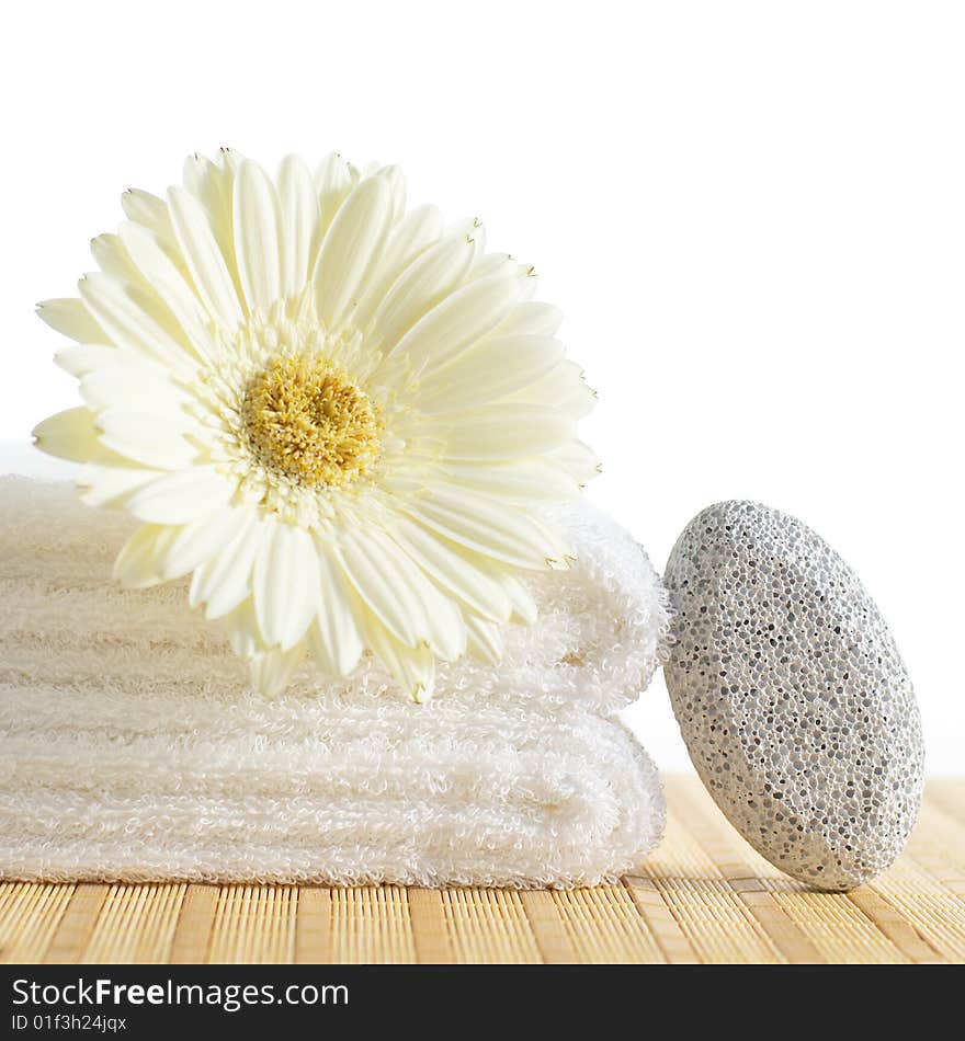 Towels, pumice stone, and flower against a white background. Towels, pumice stone, and flower against a white background.